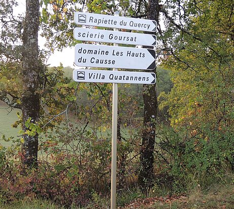 Des panneaux indiquant des gîtes et un artisan